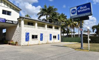"a building with a blue and white exterior , located next to palm trees and a sign that reads "" b & b west ""." at Best Western Caboolture Gateway Motel