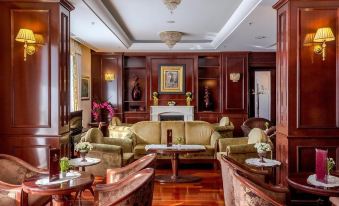 a luxurious living room with wooden furniture , including couches , chairs , and a coffee table , arranged around a fireplace at Hotel President Solin