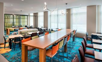 a large conference room with multiple tables and chairs , creating a comfortable and professional atmosphere at Residence Inn by Marriott Boston Watertown