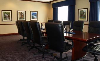 a conference room with a large table , several black chairs , and framed pictures on the wall at Hilton Garden Inn Lexington/Georgetown