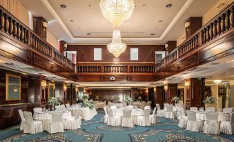 a large , ornate dining room with multiple tables and chairs arranged for a formal event at Hotel President Solin