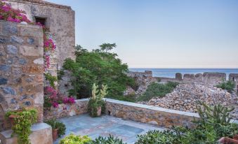 a beautiful coastal view with stone buildings , lush greenery , and a clear blue sky , along with the ocean in the background at Casa Palma