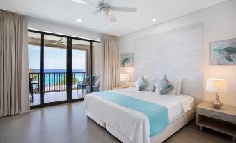 a bedroom with a large bed , blue and white bedding , and sliding glass doors leading to a balcony at Beach View Hotel