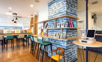 a modern bookstore with wooden tables , green chairs , and blue brick walls , creating an inviting atmosphere for customers to browse and enjoy their books at Comfort Hotel Koriyama