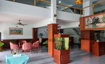 a modern , well - lit living room with wooden furniture and a large fish tank in the center at Phu nga Hotel