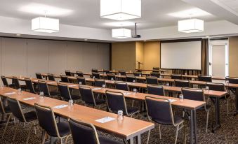 a conference room with rows of chairs arranged in a semicircle , and a projector mounted on the wall at Wyndham Avon