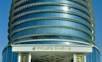 There is a large building with an entrance that leads to the main business and other office buildings in front at Yyldyz Hotel