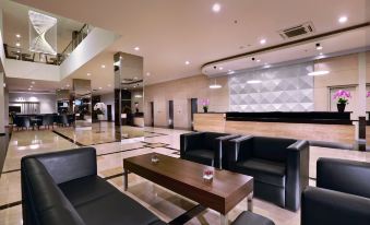 a large , well - lit lobby with various seating options including couches , chairs , and a coffee table at ASTON Imperial Bekasi Hotel & Conference Center