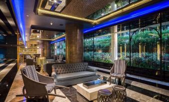 The living room features couches and chairs positioned in front of a wall adorned with large windows at Mera Mare Pattaya