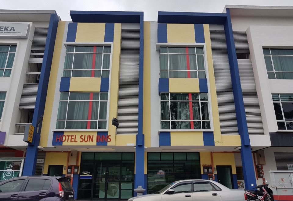 "a modern building with a blue and yellow facade , red and white striped window frames , and a sign reading "" hotel sun "" on the front" at Sun Inns Hotel Ayer Keroh