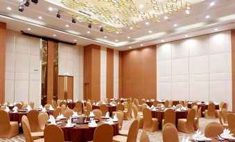a large banquet hall with multiple dining tables and chairs arranged for a formal event at Grand Fortune Hotel Nakhon Si Thammarat