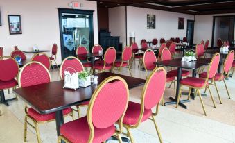 a dining room with several tables and chairs arranged for a group of people to sit and eat at Leisure Inn