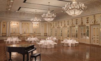 a large , elegant dining room with white tablecloths and chairs , creating a luxurious atmosphere for a wedding or formal event at Peabody Memphis