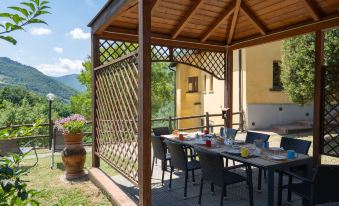 a wooden gazebo with a dining table and chairs set up for a meal , surrounded by a patio area at Villa