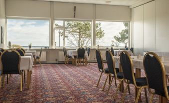 a dining room with tables and chairs set up for a formal event , possibly a wedding reception at Hotel Marina