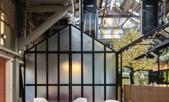 a modern office space with a glass wall , large windows , and pink chairs around a table at Ovolo Woolloomooloo