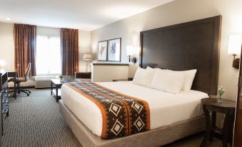 a large bed with a brown and white patterned blanket is in a hotel room at Oxford Suites Pendleton