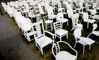 a large number of white chairs arranged in a row , possibly for an outdoor event at Diplomat Motel
