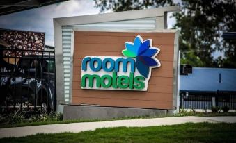 "a large sign with the words "" room hotel "" written on it , mounted on a wooden building" at Room Motels Gympie