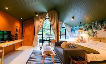 a cozy living room with a couch , chairs , and a dining table in the background at Baan Rai Darun Home Stay and Scenery Raft