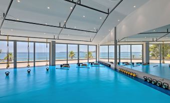 a large indoor swimming pool surrounded by windows , allowing for a view of the ocean at Le Meridien Lav Split