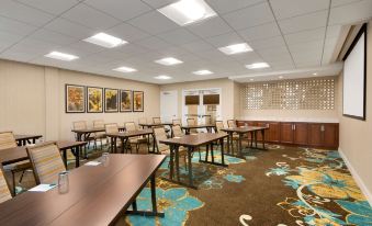 a conference room with multiple tables and chairs , a large window , and framed pictures on the wall at Homewood Suites by Hilton Augusta, ME