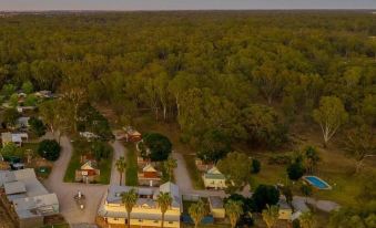 an aerial view of a residential area with houses , trees , and a pool in the distance at Deniliquin Pioneer Tourist Park
