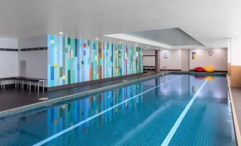 an indoor swimming pool with a colorful mural on the wall , creating a vibrant atmosphere at Meriton Suites North Ryde