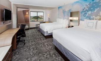 a modern hotel room with two beds , a desk , and a window offering a view of the city at Courtyard Columbus Phenix City/Riverfront