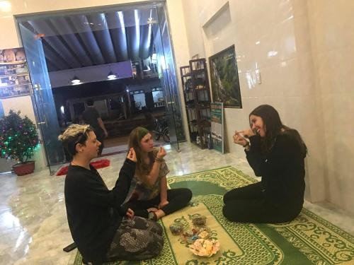 a group of three young women are sitting on the floor in a room , enjoying each other 's company at Mini Mansion