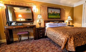 a hotel room with a king - sized bed , a dresser , and a painting on the wall at Riverside Inn