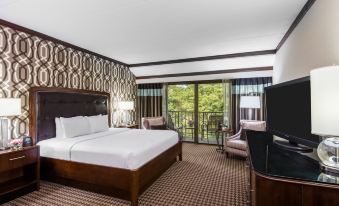 a hotel room with a king - sized bed , a television , and a balcony overlooking a lake at Hilton Alexandria Mark Center