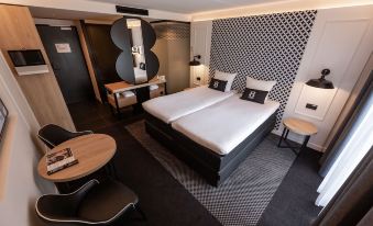 a modern hotel room with two beds , a desk , and a chair , all neatly arranged at Gr8 Hotel Sevenum