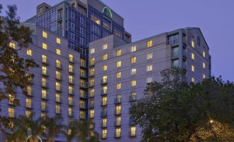 a large hotel building with a blue sky in the background , illuminated by lights at night at Hyatt Regency Sacramento