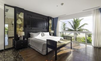 a luxurious hotel room with a large bed , a window offering a view of palm trees , and a wooden floor at Tui Blue Nam Hoi An