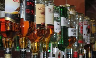 "a row of various liquor bottles on a shelf , with some labeled "" bacardi "" and "" bacardi liqueur ""." at Kincaid House Hotel