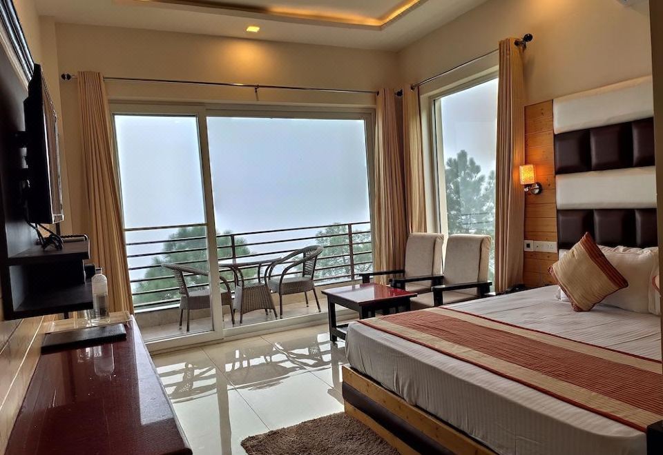 a spacious bedroom with a large bed , a dining table , and a balcony overlooking the ocean at Wood Stock