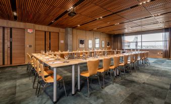 a large conference room with wooden tables and chairs arranged in rows , creating a professional setting at Hotel Indigo El Paso Downtown
