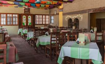 a large dining room with numerous tables and chairs arranged for a group of people to enjoy a meal together at Donaji