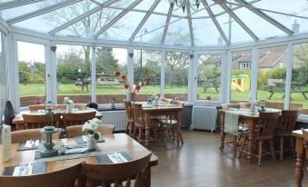 a large dining room with wooden tables and chairs arranged for a group of people to enjoy a meal together at The Babbling Brook