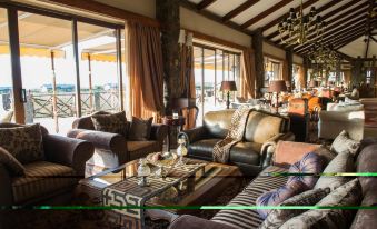 a cozy living room with multiple couches and chairs arranged around a coffee table , creating a comfortable space for relaxation and socializing at Ngorongoro Oldeani Mountain Lodge