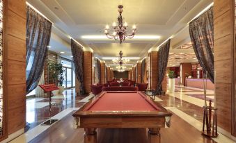 a large room with a red pool table in the center , surrounded by chairs and couches at Unahotels Expo Fiera Milano