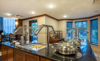a kitchen with a stainless steel range and dining table , featuring various dishes and utensils at Staybridge Suites Milwaukee Airport South