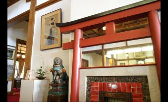 a red pillar and fireplace in a room with a painting on the wall and a statue of a cat at Nara Hotel