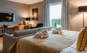 The bedroom features two beds and large windows, with an adjacent bathroom that includes a bathtub and separate shower at Clarion Hotel Aviapolis