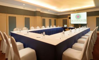 a conference room set up for a meeting , with chairs arranged in a semicircle around a long table at MetroCentre Hotel