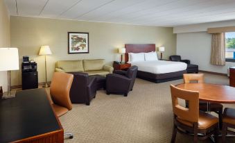 a hotel room with a bed , chairs , and dining table , along with a view of the balcony at DoubleTree Boston North Shore Danvers
