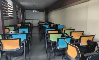 a classroom with rows of desks and chairs arranged for a group of students to sit and learn at The Beehive