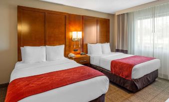 a hotel room with two beds , one on the left side and the other on the right side of the room at Comfort Suites Oakbrook Terrace Near Oakbrook Center