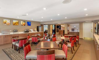 a modern and stylish dining room with wooden tables , red chairs , and a variety of chairs at Comfort Suites Oakbrook Terrace Near Oakbrook Center